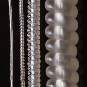 Photograph comparing muscles made by coiling (from left to right) 150 μm, 280 μm, 860 μm and  2.45 mm nylon 6 monofilament fibers.